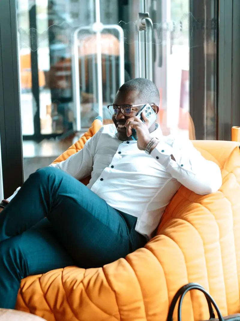 Homme d'affaires au téléphone assis dans un fauteuil orange