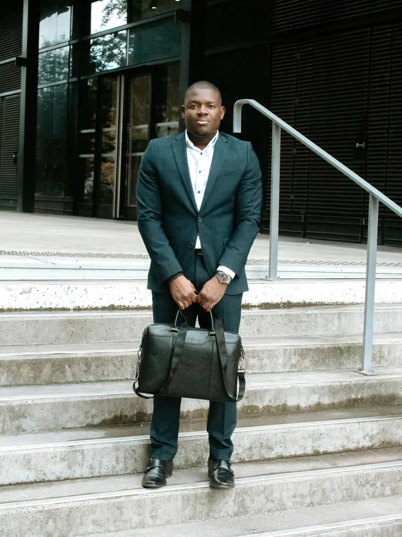Homme d'affaires avec sacoche en cuir sur les marches d'un immeuble
