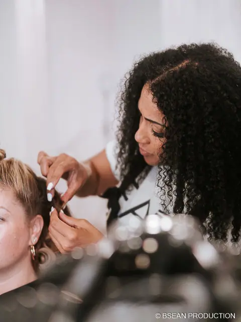 Coiffeuse en plein travail sur la chevelure d'une cliente