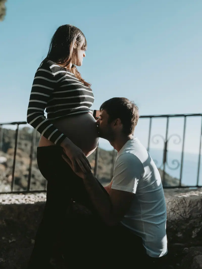 Couple attendant un bébé, le futur papa embrassant le ventre