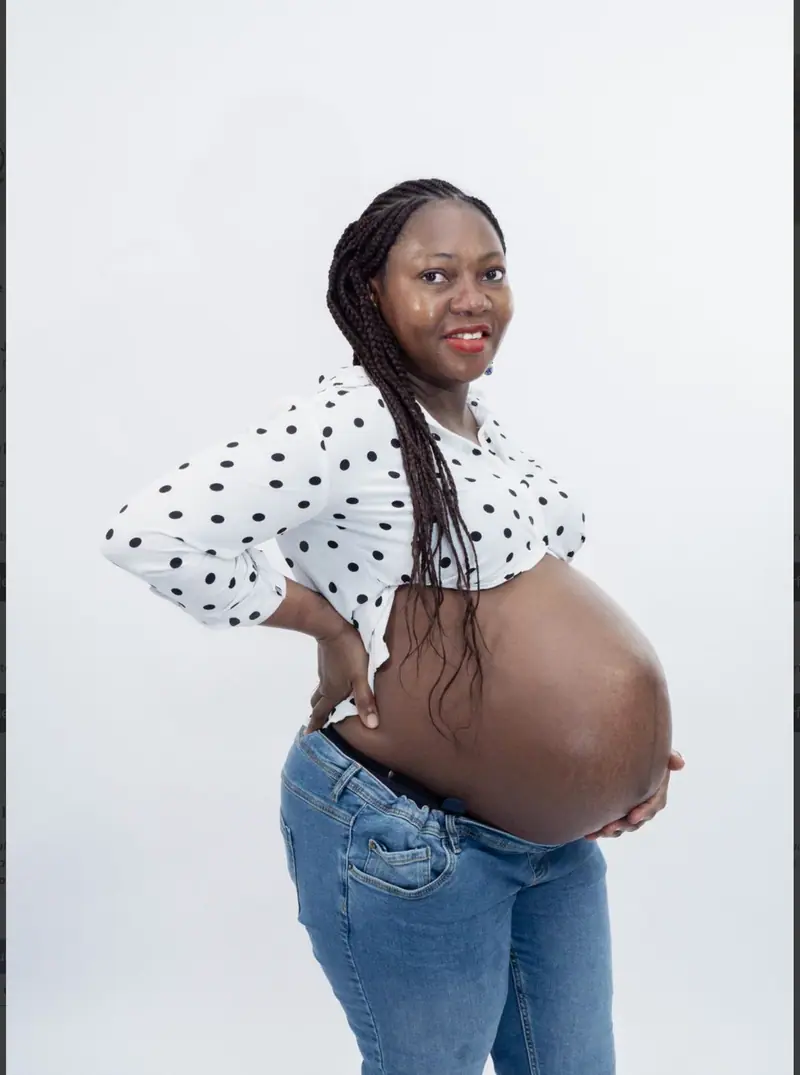 Future maman en chemise à pois montrant son ventre rond