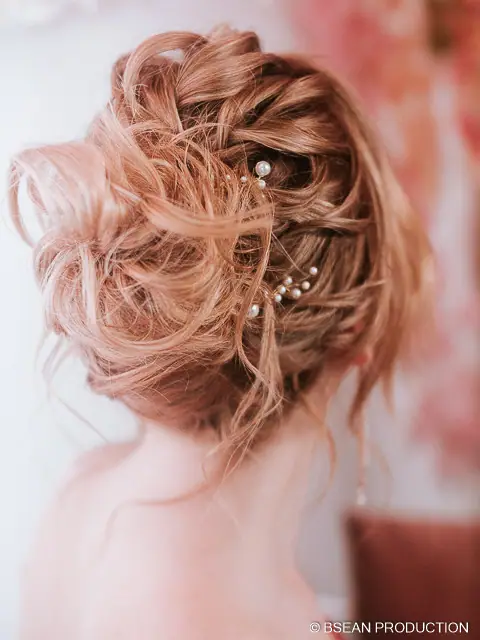 Détail de la coiffure de la mariée, chignon bouclé orné de bijoux