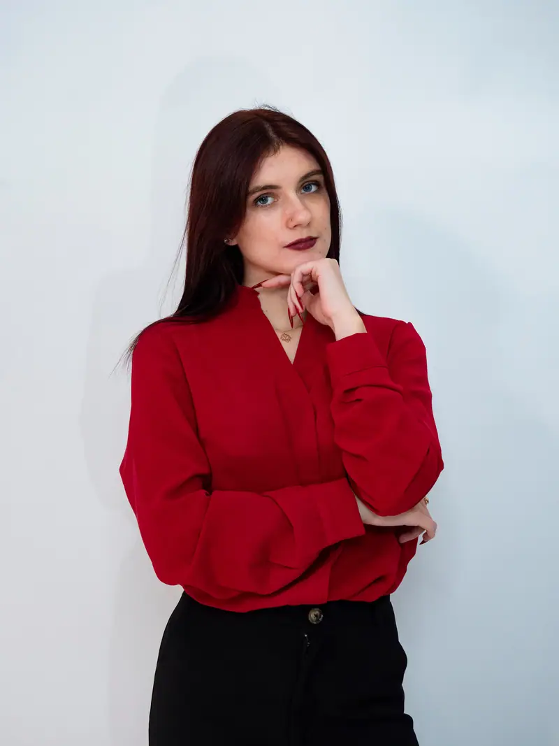 Portrait studio d'une femme en chemise rouge sur fond blanc