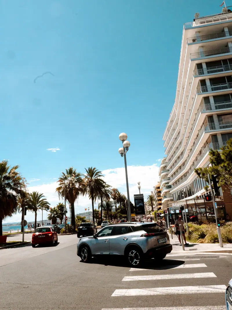 Avenue ensoleillée avec palmiers et immeubles à Nice
