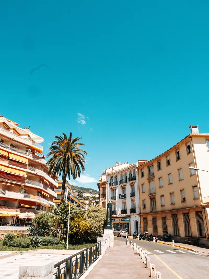 Rue de Menton bordée de palmiers et de façades colorées